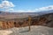 Desert hiking, Ubehebe Crater view point, and warning sign `Use caution near the edge` in Death Valley National Park