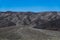 A desert landscape of barren hills of black volcanic rock