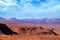 Desert landscape of red rocky formations and volcanoes near San Pedro de Atacama, Chile, against a blue sky covered by