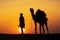 A desert local walks a camel through Thar Desert