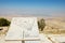 Desert mountain landscape with plaque showing the distances from Mount Nebo to various locations at Mount Nebo, Jordan.