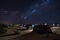 desert night sky with stars and moon shining down on rows of tents