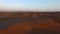 Desert people rolling on the sand dunes during the red and golden sunset