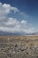 Desert plain with small shrubs and rocks. Mountains in distance