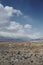 Desert plain with small shrubs and rocks. Mountains in distance