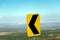 Desert road curve in Atacama: yellow sign and barren landscape of desert