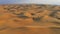 Desert Safari off-roading, group of jeep or SUV or 4x4 car vehicle rides on desert dune barkhan or sand-dune. Aerial