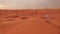 Desert sand dunes with man walking.