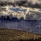 Desert storm clouds gather over green power windmills.