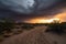 desert storm rolling in, with dramatic sunset and clouds in the background