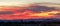 A desert sunset panorama with a saguaro cactus silhouetted against the evening sky in the Sonoran