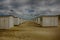 Desert surrounded by small cabins under a cloudy sky on a gloomy day