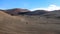 Desert wasteland. Volcanic mountain range in the background.