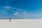 Desert with white sand and female in black