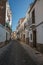 Deserted alley with old terraced buildings with worn plaster in Caceres