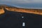 A deserted asphalt road running away into the hills. Iceland. The spirit of travel and adventure.