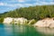 Deserted beach with clear turquoise water on old lake formed on site of chalk quarry in Grodno Belarus in summer sunny day with