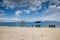 A deserted beach with an umbrella on one of the Islands of the Great Barrier Reef in Australia. A small white ship is a little to