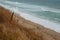 Deserted beach with wild steep banks with grass.