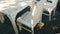 Deserted cafe with white wooden chairs on the seashore. Cafe table on seaside