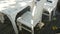 Deserted cafe with white wooden chairs on the seashore. Cafe table on seaside