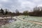 Deserted city park covered with layer of fresh snow on an early winter morning