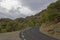 A deserted narrow winding road passing through the Mountain Scenery of central Andalusia.