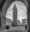 Almost deserted Piazza del Duomo framed by an arch of the Palazzo del Comune, Pistoia, Tuscany, Italy