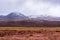Desertic prairie and snowy volcanic mountains at Atacama desert