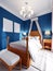 Design of a children`s bedroom, four-poster bed, nightstands with table lamps. Blue, orange, white color of the interior