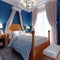 Design of a children`s bedroom, four-poster bed, nightstands with table lamps. Blue, orange, white color of the interior