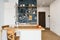 Design of modern home kitchen in the attic and rustic style. Black wall with shelves, trays, jars, mugs. Refrigerator, dining tabl