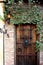 Design of old wooden door with ornate details covered in thick Ivy, Museum of the Weird, downtown Austin, Texas, 2018