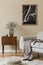 Design scandinavian home interior of living room with mock up poster map, stylish wooden commode, sofa and flowers in vase.