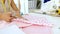 Designer cutting pink cloth with scissors