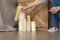 Designer girl arranges decorative candles near bed and bedside table.