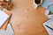 Designer workspace with headphone, pencil holder, coffee cup and notebook on wooden desk.