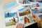 Desire to travel during pandemic. Top view of a woman watching her image prints with surgical mask on pocket-size case on