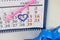 Desk calendar, pink pencil. 14 circled in red in the shape of a heart. Have a gift box