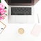 Desk with female workspace with laptop, pink roses, coffee mug, pink diary on white background. Flat lay. Top view. Fashion or fre