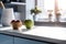 Desk of free space and kitchen interior, wooden table, kitchen window and shelves. Aesthetic photo, macro close up