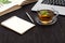 Desk with laptop, eyeglasses and a cup of tea on a wooden table