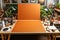 A desk with a large orange piece of paper surrounded by craft supplies. Copy space