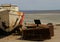 Desk, monitor and office chair by abandoned boat.