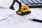 Desktop with blueprint yellow mini excavator, ruler and pencil