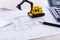 Desktop with blueprint yellow mini excavator, ruler and pencil