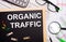 The desktop has a calculator, reports, glasses, a magnifying glass, pens and a board with clothespins and text ORGANIC TRAFFIC.