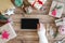 Desktop mock up tablet. Flat lay of woman s hand with smartphone, wrapping Christmas gift. Presents on wooden background