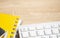 Desktop table with keyboard, calculator and yellow book on the brown wood table