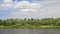 Desna river in summer with green trees and clouds in blue sky